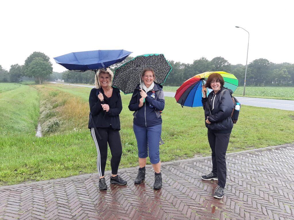 Drie dames in de regen met een paraplu